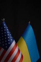 Closeup of United States and Ukraine flags on black background.