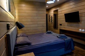 Hotel room with wooden interior, bed and night light