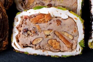 Sliced ​​Turkish delight roll with cream filling, pistachio, almond and hazelnut. Local name: fistikli fitil lokum. Close-up
