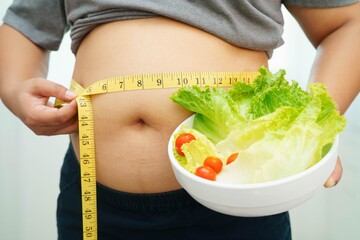 Asian woman with fat belly big size overweight and obesity with healthy food.