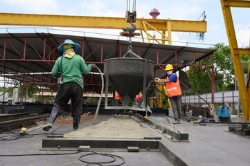 Workers are pouring cement and casting blocks to prepare for sale.
