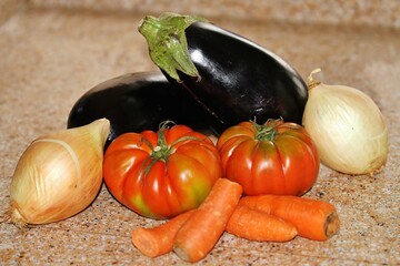 Comida sana y saludable con hortalizas con berenjena, tomates, cebollas y zanahoria sobre la...