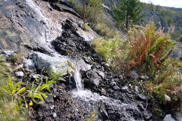stream of clear water on a rock in the mountains.
