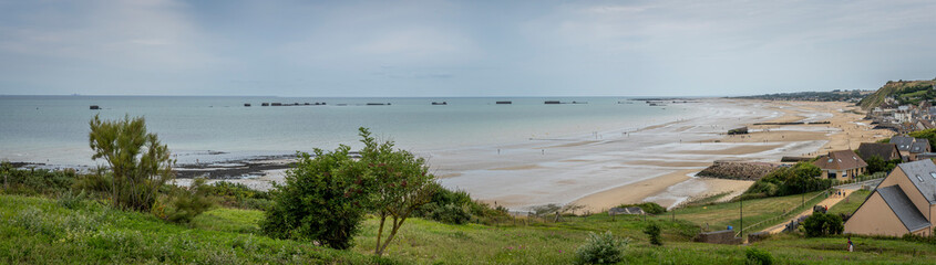 Arromanches-les-Bains, France - 08 08 2025:  Normandy landing blockhouse. Panoramic view of the artificial port, the beach, the sea, cliffs and the city