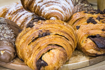Croissant with chocolate and powder sugar on market stall or in confectionery shop