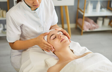 Facial massage of woman for skin rejuvenation, lifting and spa relax of woman by cosmetologist. Top...