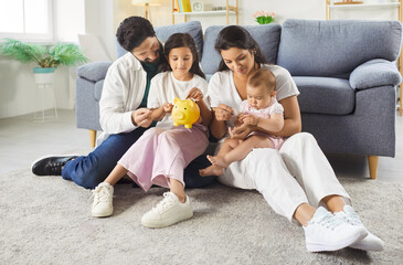 Parents saving money for future children education, collecting coins in piggy bank, wanting to buy...