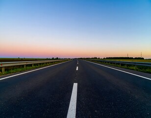 Fototapeta premium Open Highway Stretches Under a Pastel Sky During Sunset in Rural Landscape