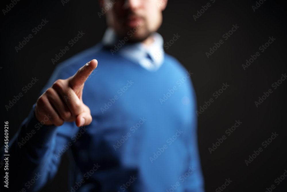 Poster man in blue sweater points forward, indicating importance in a minimalist setting