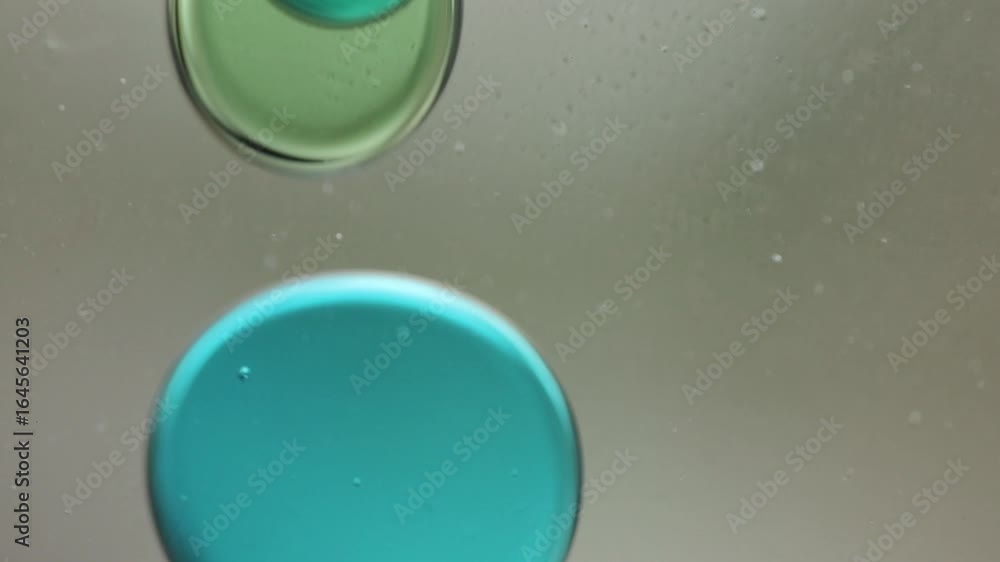 Poster close-up of blue and green liquid with floating bubbles and blobs in motion inside a lava lamp, view