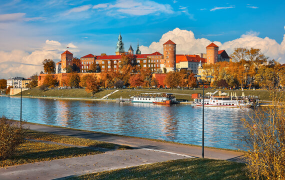 Krakow Poland. Wawel castle the Wisla river banks. Autumn sunset with blue sky and white clouds. Sunny evening scene.
