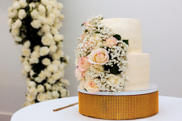 Stunning wedding cake with fresh flowers graces beautifully decorated venue for special event.
