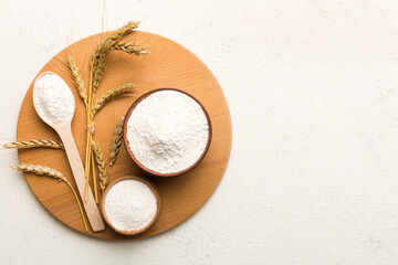 Flat lay of Wheat flour in wooden bowl with wheat spikelets on colored background. world wheat...