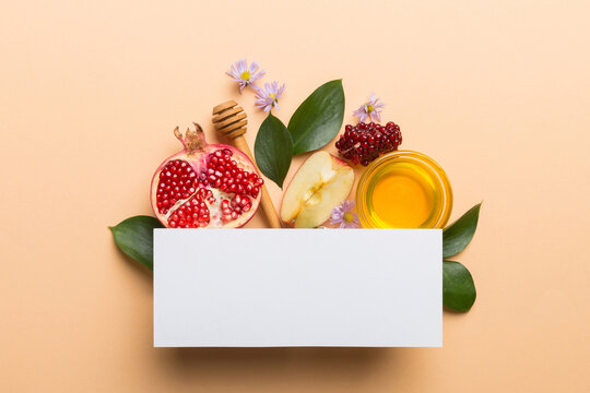 Flat lay composition with Blank flyer poster and symbols jewish Rosh Hashanah holiday attributes on colored background, New Year holiday Traditional. Top view with copy space mock up