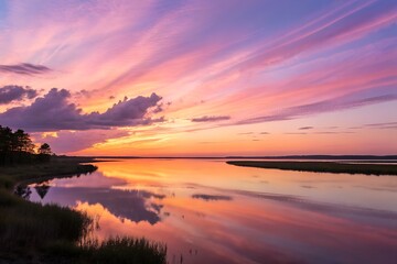 Obraz premium Colorful sunset reflecting on calm water creates a serene and beautiful landscape