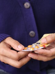 Close up, a person's hand holds an appetite-enhancing pill.