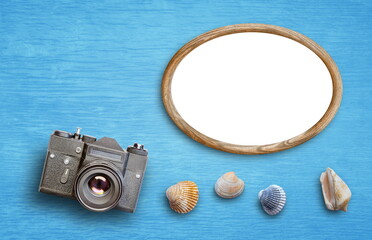 wooden frame retro camera and sea shells on blue background
