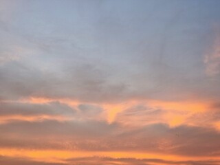 Peaceful evening sky with soft orange clouds during sunset