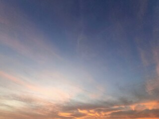 Peaceful evening sky with soft orange clouds during sunset