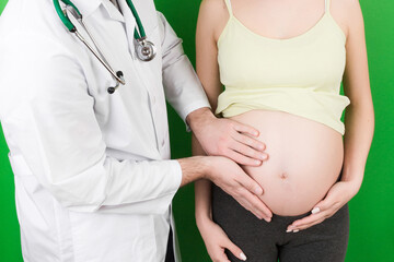Happy doctor caring about young pregnant woman. doctor using hand examining pregnant woman in clinic