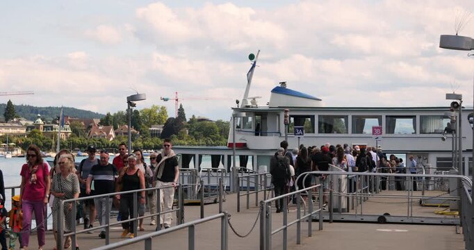 17-07-2025 Zurich, Switzerland. Tourists disembarking from a ferry boat on the main pier of lake Zurich. Sunny summer day, real time footage