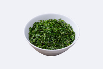 Cooked kale strips, typical brazilian feijoada sidedish in a bowl isolated over white background