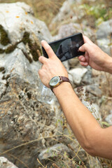 Man taking picture in nature by smartphone.