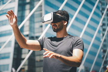 Man interacting with a virtual environment using VR headset in a modern city. Concept of immersive technology, augmented experience, future innovation, and urban digital transformation.