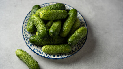 Fresh cucumbers arranged on a decorative plate, ready for meals and snacks in a kitchen setting
