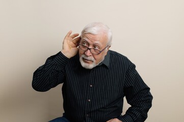 Older man leaning forward with glasses, listening intently, demonstrating curiosity and engagement...
