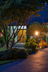 Obraz premium Entrance of luxury house with nice green Summer landscape at night in Vancouver, Canada, North America. August 2025.