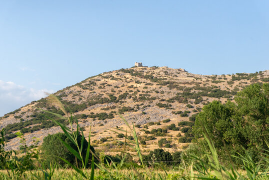 View of a dry hill crowned with the remains of a stone watchtower, near the ancient fortifications of Philippi