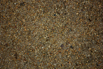 Abstract close-up texture of a sand and small pebbles surface. Natural background.