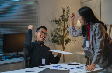 Obraz premium Excited business team celebrating success in office at night