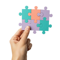 A human hand carefully holds a completed nine-piece jigsaw puzzle, displaying soft pastel colors, representing unity, problem-solving, and successful completion of a task.