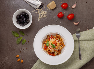 Top view of Italian pasta with grilled vegetables, parmesan cheese, fresh basil and black olives...