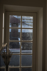 Fototapeta premium View Through a Window with Rooftops in Stavanger, Norway