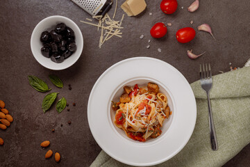 Top view of Italian pasta with grilled vegetables, parmesan cheese, fresh basil and black olives...