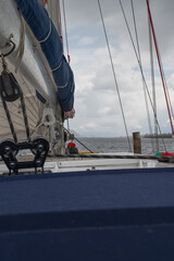 Sailboat Deck with Rigging and Shoreline in a Fjord Setting