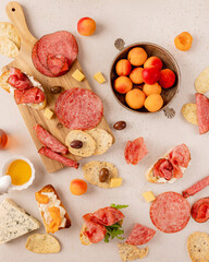 Summer picnic brunch board with Italian salami, artisan bread, creamy soft cheese, olives,...