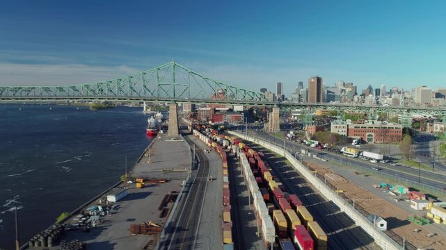 Freight train carrying shipping containers passes under the Jacques Cartier Bridge in Montreal, Canada. The containers are being transported for import/export.
