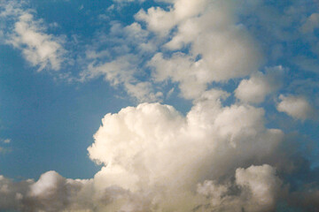 Obraz premium White fluffy cumulus clouds on blue sky
