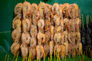 Shrimp satay at Angkringan, a traditional street food from Indonesia, on green banana leaves