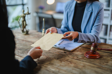 Lawyer giving envelope to client during legal consultation