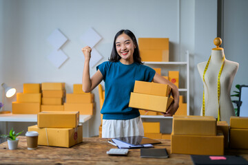 Asian Female Seller Holding Parcel Boxes and Celebrating Success in Fashion Online Business