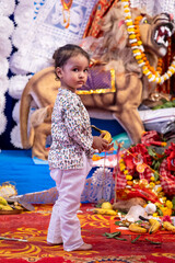 decorated durga idol with kid folded-hand devotee at dussehra in day