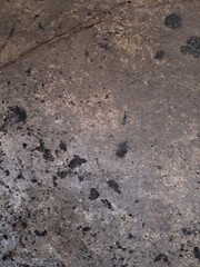 A gray footprint in the sand with a rough, textured, grunge pattern of old concrete and rock