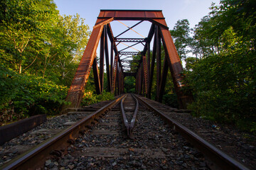 Rusted Steel Railroad Bridge Over Train Tracks in New England
