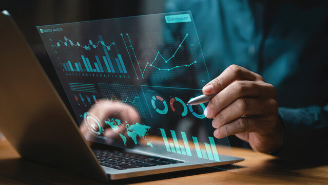 Modern business analyst reviewing data on futuristic laptop with glowing charts and graphs today