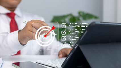 Business strategy, goal setting, marketing objectives, and achieving success in a professional environment.Businessman uses stylus on digital screen with target and goals list.